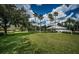 Expansive green lawn leads to a community pool area with palm trees and a blue and white cabana, offering relaxation at 15925 Pond Rush Ct, Land O Lakes, FL 34638