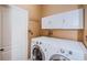 Convenient laundry room featuring a washer, dryer, and storage cabinets at 15925 Pond Rush Ct, Land O Lakes, FL 34638