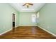 A bright main bedroom featuring a trey ceiling, ceiling fan and wood floors at 15925 Pond Rush Ct, Land O Lakes, FL 34638