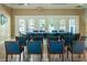 The meeting room boasts tile floors, neutral walls, and a large table adorned with blue chairs, under the EXIT sign at 15925 Pond Rush Ct, Land O Lakes, FL 34638