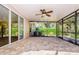 A screened patio with a ceiling fan and brick flooring offers a comfortable outdoor living space at 15925 Pond Rush Ct, Land O Lakes, FL 34638