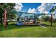 A well-equipped, covered neighborhood playground with slides, ladders, and benches, set in lush green surroundings at 15925 Pond Rush Ct, Land O Lakes, FL 34638
