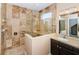 Bathroom with marble walk-in shower with glass partition and dark cabinets at 15925 Pond Rush Ct, Land O Lakes, FL 34638