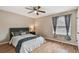Cozy bedroom features a ceiling fan, window with curtains, and wood-look laminate flooring at 16064 Dawnview Dr, Tampa, FL 33624