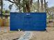 A charming backyard shed with a painted blue door, a stepping stone walkway, and surrounding natural beauty at 1731 W Perio St, Tampa, FL 33612