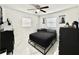 Modern bedroom with tile floors, a ceiling fan, and minimalist decor offers a sleek and relaxing atmosphere at 1731 W Perio St, Tampa, FL 33612