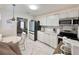 Bright kitchen with white cabinets, appliances and a view of the dining and living room at 1731 W Perio St, Tampa, FL 33612