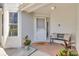 Inviting front porch with brick flooring, a comfortable bench, and potted plants creating a welcoming entryway at 1955 Georgia N Cir, Clearwater, FL 33760