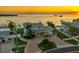 Stunning aerial view showcasing the home, waterfront, and lush landscaping under a breathtaking orange sunset at 200 Driftwood W Dr, Palm Harbor, FL 34683