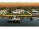 Backyard view featuring a waterfront home with private dock, boat lift, and manicured lawn, perfect for outdoor living at 200 Driftwood W Dr, Palm Harbor, FL 34683