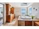 Bathroom with wood cabinets, tan tile, a soaking tub and a view to the water through a large picture window at 200 Driftwood W Dr, Palm Harbor, FL 34683