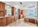 Spacious bathroom featuring dual vanities, marble floors and countertops, and separate tub at 200 Driftwood W Dr, Palm Harbor, FL 34683