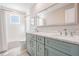Bathroom with dual sinks, blue vanity, and shower with white tile at 200 Driftwood W Dr, Palm Harbor, FL 34683