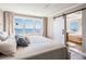 Comfortable bedroom with a water view from the large window and barn-style door to the bathroom at 200 Driftwood W Dr, Palm Harbor, FL 34683
