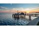 Waterfront dock with boat lift under a colorful sunset sky at 200 Driftwood W Dr, Palm Harbor, FL 34683