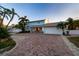 Charming home featuring lush landscaping, brick driveway, and an attached garage at 200 Driftwood W Dr, Palm Harbor, FL 34683