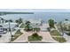 Beautiful waterfront home showcasing the brick paver driveway and meticulous landscaping with tropical palms at 200 Driftwood W Dr, Palm Harbor, FL 34683