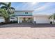 Charming two-story home with a brick driveway and lush tropical landscaping at 200 Driftwood W Dr, Palm Harbor, FL 34683
