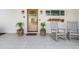 Inviting front porch featuring rocking chairs, potted plants, a decorative fish skeleton, and a 'hello' doormat at 200 Driftwood W Dr, Palm Harbor, FL 34683