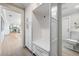 Hallway features hardwood floors and opens to kitchen and white cabinets and drawers at 200 Driftwood W Dr, Palm Harbor, FL 34683