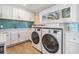 Bright laundry area with white cabinets, sink, and stainless steel appliances at 200 Driftwood W Dr, Palm Harbor, FL 34683