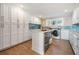 White laundry room with blue tile backsplash and stainless appliances at 200 Driftwood W Dr, Palm Harbor, FL 34683
