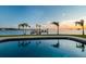 Tranquil pool reflecting the sunset and palm trees on the waterfront property at 200 Driftwood W Dr, Palm Harbor, FL 34683