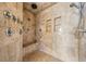 Walk in shower with stone tiling and multiple shower heads and shower bench at 200 Driftwood W Dr, Palm Harbor, FL 34683