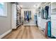 Walk-in closet features custom shelving, hanging racks and light wood floors at 200 Driftwood W Dr, Palm Harbor, FL 34683
