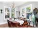 Charming dining room with hardwood floors, decorative chandelier, and ample natural light from large windows at 201 72Nd N St, St Petersburg, FL 33710