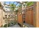 Outdoor shower area with wooden structure, lush greenery, and convenient shelving for a spa-like experience at 201 72Nd N St, St Petersburg, FL 33710