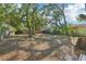 Spacious backyard featuring mature trees and a wooden fence is ideal for outdoor entertaining and recreational activities at 2111 E Ellicott St, Tampa, FL 33610