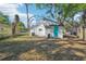 Large backyard featuring a turquoise door and mature shade trees at 2111 E Ellicott St, Tampa, FL 33610