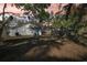 Large backyard featuring mature trees and a white house with a bright blue door for private, shaded retreat and outdoor living at 2111 E Ellicott St, Tampa, FL 33610