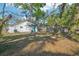 Backyard with mature trees shading a tidy lawn and a cute turquoise door at 2111 E Ellicott St, Tampa, FL 33610