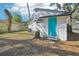 A quaint backyard featuring a bright blue door and a natural landscape offers a private and charming outdoor space at 2111 E Ellicott St, Tampa, FL 33610