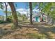 A spacious backyard with mature trees offers a private, shaded retreat perfect for outdoor activities and relaxation at 2111 E Ellicott St, Tampa, FL 33610