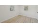 Bright bedroom featuring two windows and neutral paint with wood look flooring at 2111 E Ellicott St, Tampa, FL 33610