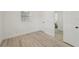 Clean bedroom with white paint, two windows, and light wood-look flooring at 2111 E Ellicott St, Tampa, FL 33610