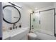 Modern bathroom features sleek, white tile, a round mirror, and a glass-enclosed shower at 215 Central Ave # 4H, St Petersburg, FL 33701