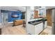 Open concept living room with blue accent wall, hardwood floors, modern appliances, and brick accents at 215 Central Ave # 4H, St Petersburg, FL 33701