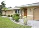 Charming front entrance with a well-maintained lawn, tasteful landscaping, and a welcoming wooden door at 229 Tazewell Dr, Port Charlotte, FL 33954