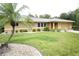 Charming single-story home with a well-manicured lawn, a palm tree, and an attached garage at 229 Tazewell Dr, Port Charlotte, FL 33954