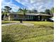 Charming single-story home featuring a lush green lawn and a decorative palm tree in the front yard at 229 Tazewell Dr, Port Charlotte, FL 33954