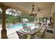 Inviting covered patio featuring outdoor seating, a ceiling fan, and views of the pool and backyard at 229 Tazewell Dr, Port Charlotte, FL 33954