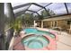 Beautiful screened-in pool and spa area with lush landscaping and ample space for outdoor relaxation at 229 Tazewell Dr, Port Charlotte, FL 33954