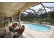 Inviting screened-in pool with a spa, surrounded by comfortable outdoor seating, and well lit with a ceiling fan at 229 Tazewell Dr, Port Charlotte, FL 33954
