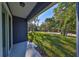 Grassy backyard with mature trees and shadows from the back porch at 2807 W Granfield Ave, Plant City, FL 33563