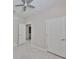 Spacious bedroom with ceiling fan, plank floors, and views into a bathroom at 2807 W Granfield Ave, Plant City, FL 33563