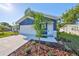 Charming blue home with landscaped front yard, showcasing curb appeal and a two-car garage at 2807 W Granfield Ave, Plant City, FL 33563